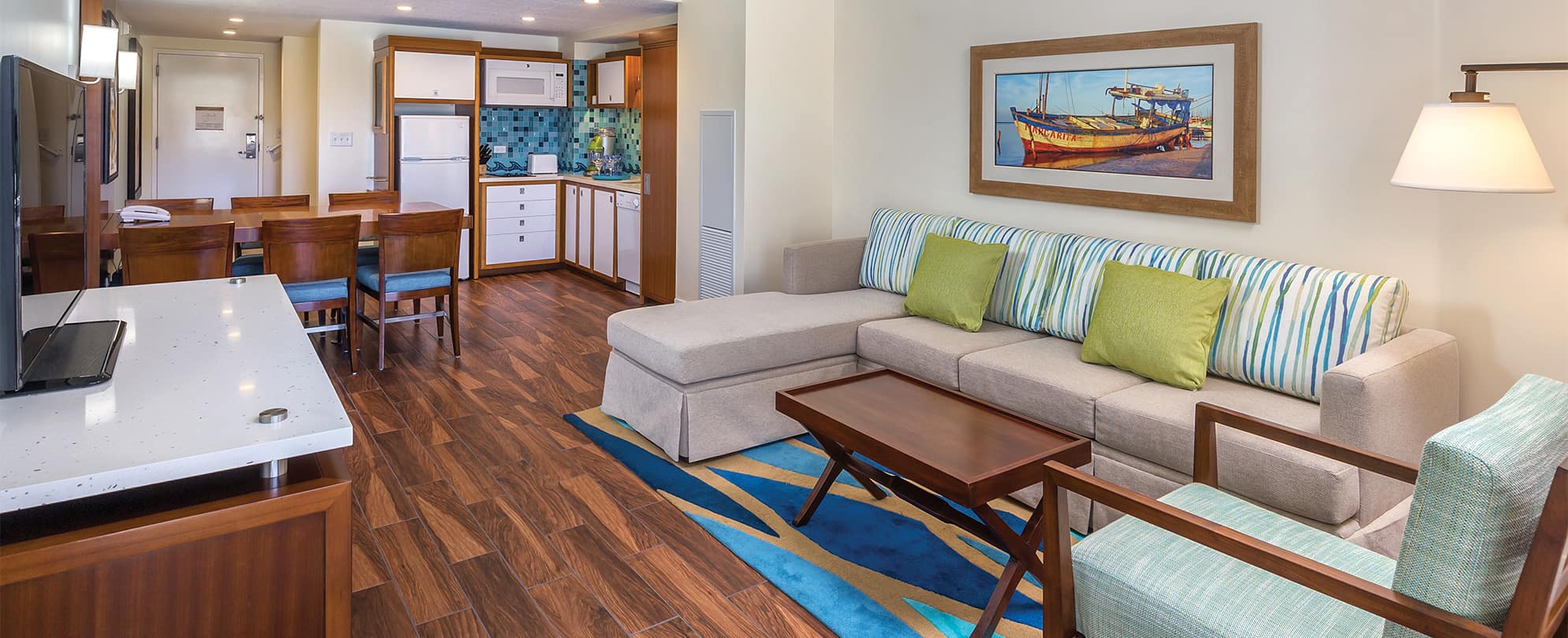 Living room, dining room, and kitchen in a Margaritaville Vacation Club by Wyndham - St. Thomas suite.