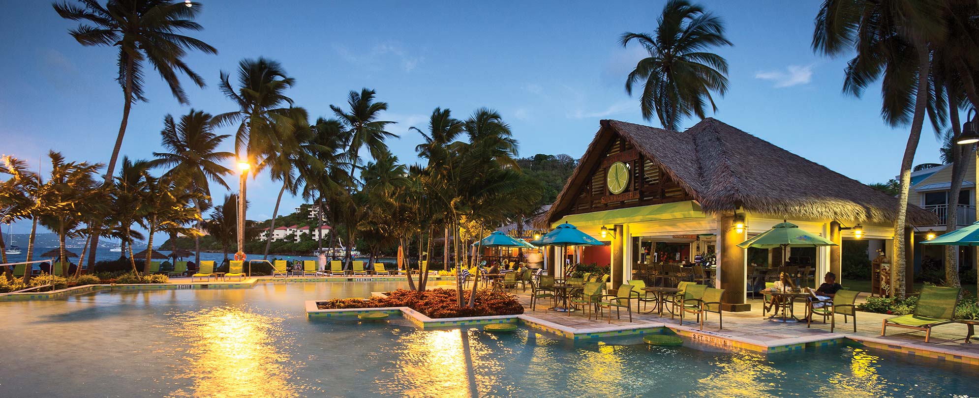 The oceanfront pool and tiki bar in the evening at Margaritaville Vacation Club by Wyndham - St. Thomas, a timeshare resort.