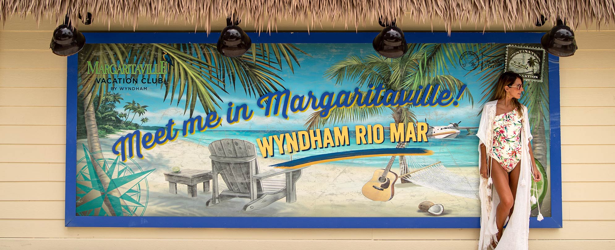 Woman standing by of sign that reads "Meet Me in Margaritaville. Wyndham Rio Mar" at a Margaritaville Vacation Club resort.